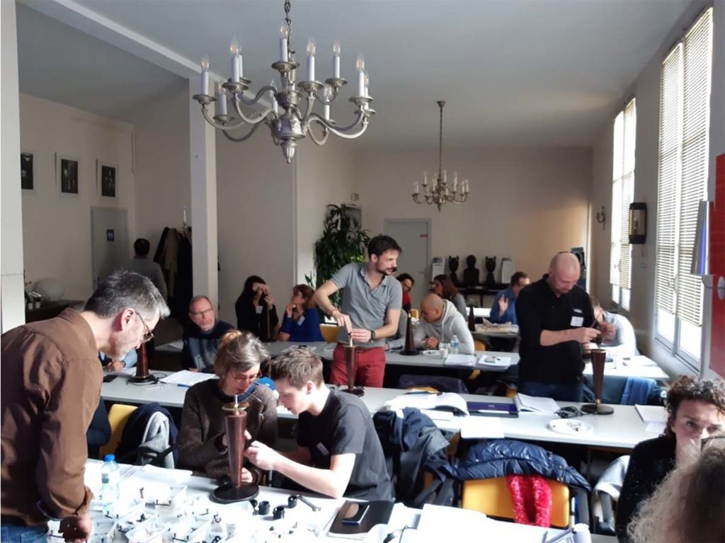 participants manipulant des luminaires lors d’un atelier de formation à la réglementation des luminaires